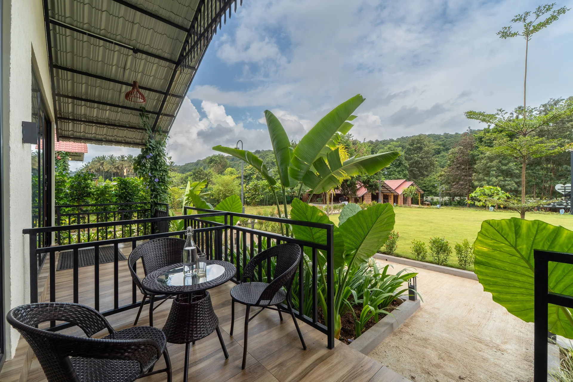 Premium Cottage balcony overlooking the lawn at Nadi Teera, Dandeli